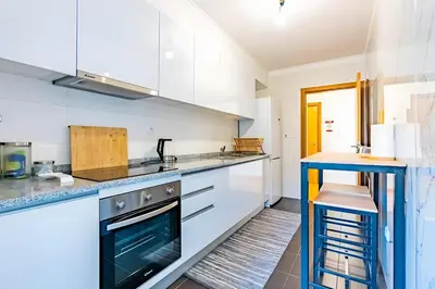 a kitchen with white cabinets and a stove at Casa Sol in Caniço