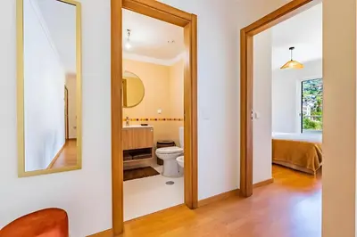 a bathroom with a toilet and a mirror at Casa Sol in Caniço
