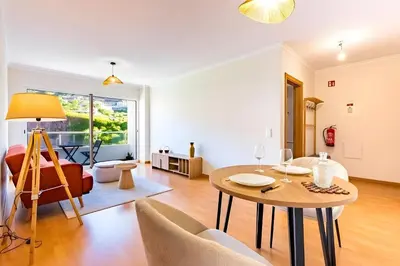 a living room with a table and a chair at Casa Sol in Caniço