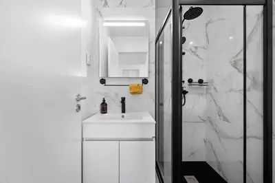 a white bathroom with a sink and a shower at Casa Lobos in Câmara de Lobos