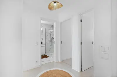 a white bathroom with a shower and a rug at Casa Lobos in Câmara de Lobos
