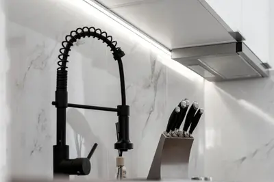 a kitchen sink with a black faucet and a knife holder at Casa Lobos in Câmara de Lobos