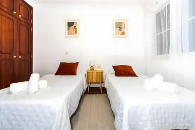 a white bedroom with a bed and a window at City Views Apartment Funchal in Funchal