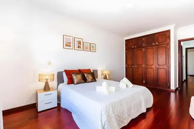 a bedroom with a white bed and a wooden cabinet at City Views Apartment Funchal in Funchal