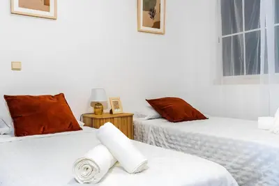two beds in a room with white walls at City Views Apartment Funchal in Funchal