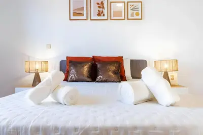 a bedroom with a white bed with two lamps at City Views Apartment Funchal in Funchal