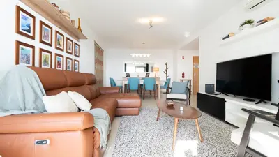 a living room with a brown leather couch and a television at Amethyst by LovelyStay in Caniço