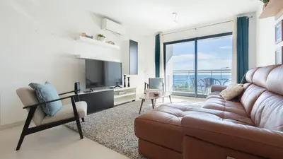 a living room with a couch and a television at Amethyst by LovelyStay in Caniço