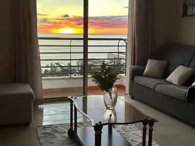 a living room with a couch and a vase on a table at Forum Madeira pokoje in Funchal