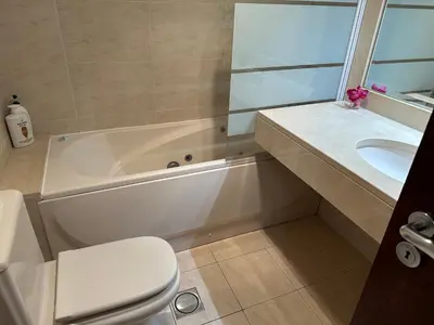 a bathroom with a tub and a toilet and a sink at Forum Madeira pokoje in Funchal