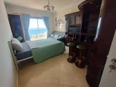 a bedroom with a bed and a television and a window at Forum Madeira pokoje in Funchal
