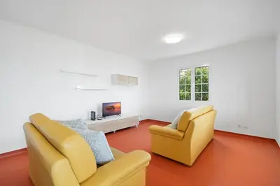 a living room with two chairs and a tv at Caniço Seaview House in Caniço