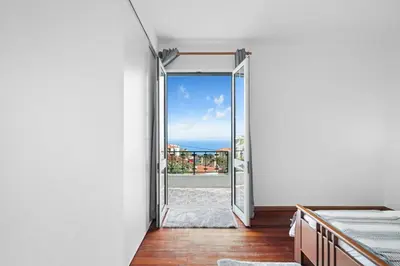 a room with a door leading to a balcony at Caniço Seaview House in Caniço