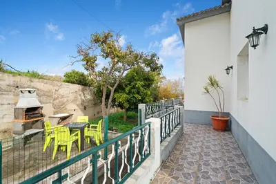 a balcony with a table and chairs and a grill at Caniço Seaview House in Caniço
