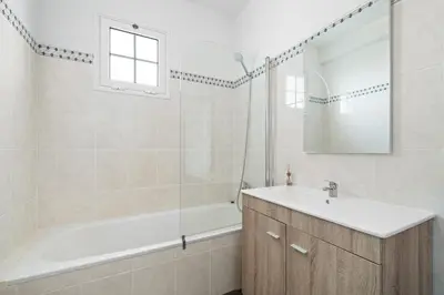 a bathroom with a tub and a sink and a mirror at Caniço Seaview House in Caniço