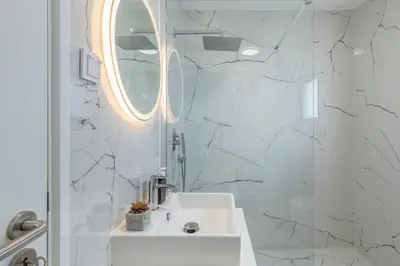 a white bathroom with a sink and a mirror at Luna do Mar - Luxury apt with Jacuzzi in Gaula