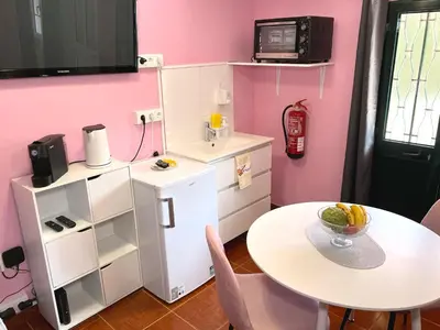 a small kitchen with a table and a small refrigerator at Casa Levada Explorer - Cozy Nights & Easy Meals in Santana