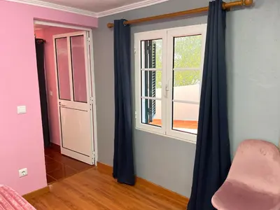 a room with blue curtains and a window at Casa Levada Explorer - Cozy Nights & Easy Meals in Santana