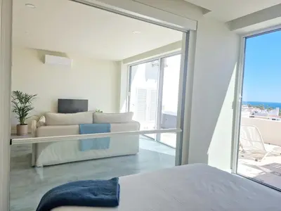 a bedroom with a couch and a large glass window at Romantic Escape - Private jacuzzi and WOW seaview in Lagos