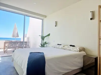 a bedroom with a bed with a view of the ocean at Romantic Escape - Private jacuzzi and WOW seaview in Lagos