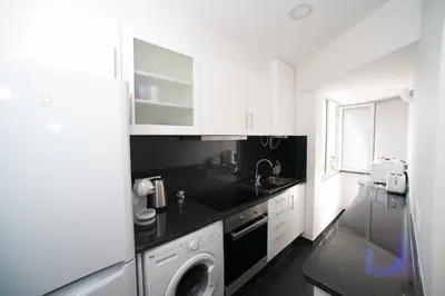 a white kitchen with a sink and a dishwasher at Madeira Sun in Funchal