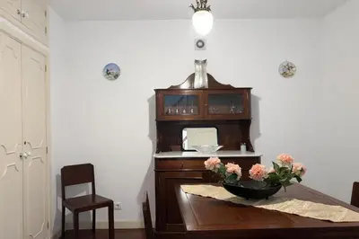 a room with a table with a vase of flowers on it at Violeta House in Funchal