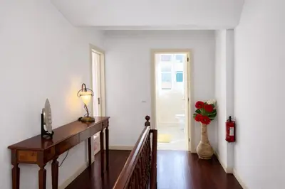 a hallway with a staircase and a vase with flowers in it at Violeta House in Funchal