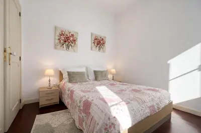 a bedroom with a bed and two paintings on the wall at Violeta House in Funchal