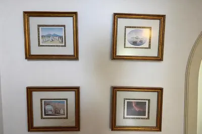 a group of framed pictures on a wall at Violeta House in Funchal