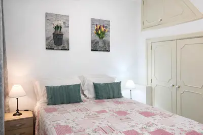 a bedroom with a bed with three pictures on the wall at Violeta House in Funchal