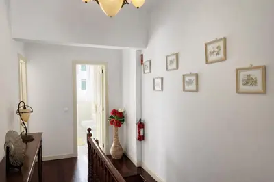 a white hallway with a vase with flowers in it at Violeta House in Funchal