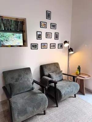 a living room with two chairs and a table at Casa do Til in Porto Moniz