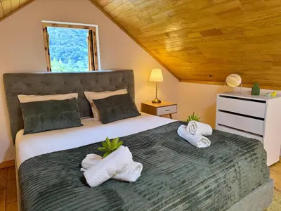 a bedroom with a large bed with towels on it at Casa do Til in Porto Moniz
