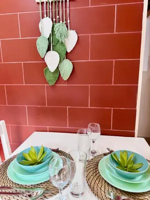 a table with green plates and glasses on it at Casa do Til in Porto Moniz