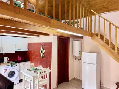 a small kitchen with a staircase in a house at Casa do Til in Porto Moniz