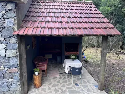 a small house with a table and a red roof at Casa do Til in Porto Moniz