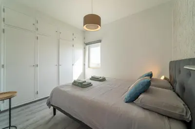 a bedroom with a bed and a window at Ocean View Apartment near Arrifana Beach with Parking in Aljezur