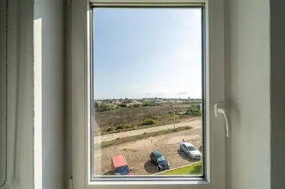 a window with two cars parked in a field at Ocean View Apartment near Arrifana Beach with Parking in Aljezur