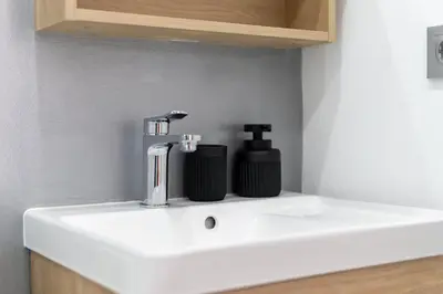 a bathroom sink with a soap dispenser on it at Ocean View Apartment near Arrifana Beach with Parking in Aljezur