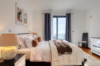a bedroom with a large bed and a window at Oasis do Sol, a Home in Madeira in Ponta do Sol