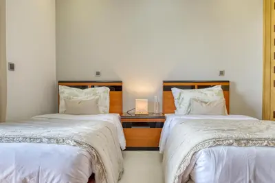 two beds in a room with white sheets and pillows at Oasis do Sol, a Home in Madeira in Ponta do Sol