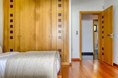 a bedroom with a bed and a wooden door at Oasis do Sol, a Home in Madeira in Ponta do Sol
