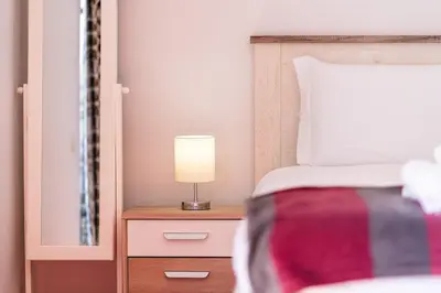 a bedroom with a bed with a lamp on a night stand at GuestReady - Alluring island retreat in Santa Cruz