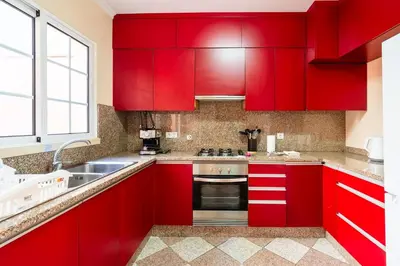 a kitchen with red cabinets and a sink at GuestReady - Alluring island retreat in Santa Cruz