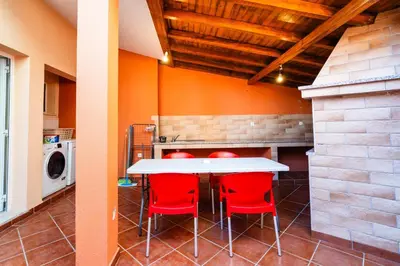 a kitchen with a white table and red chairs at GuestReady - Alluring island retreat in Santa Cruz