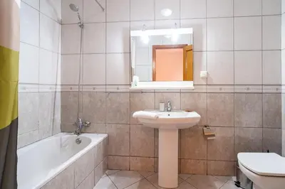 a bathroom with a sink and a toilet and a tub at GuestReady - Alluring island retreat in Santa Cruz