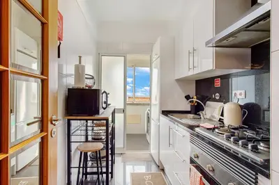 a kitchen with white cabinets and a stove top oven at Ti Clara Serenity Apartment in Caniço