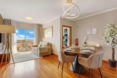 a dining room and living room with a table and chairs at Ti Clara Serenity Apartment in Caniço