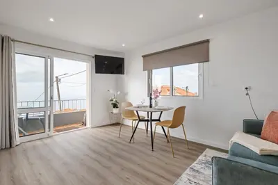 a living room with a table and chairs and a couch at Casa Avô ladeira 2 in Estreito da Calheta