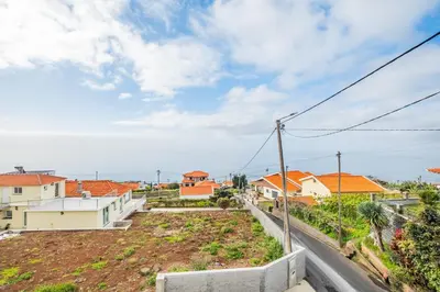 a street in a residential neighborhood with houses at Casa Avô ladeira 2 in Estreito da Calheta
